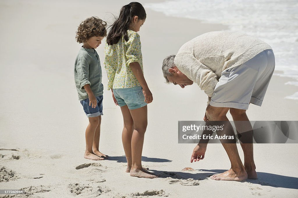 Children with their grandfather on the beach