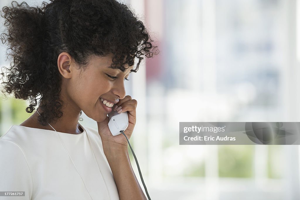 Close-up of a woman talking on a landline phone