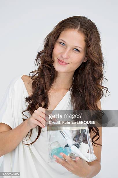 portrait of a woman holding a make-up bag - make up bag fotografías e imágenes de stock