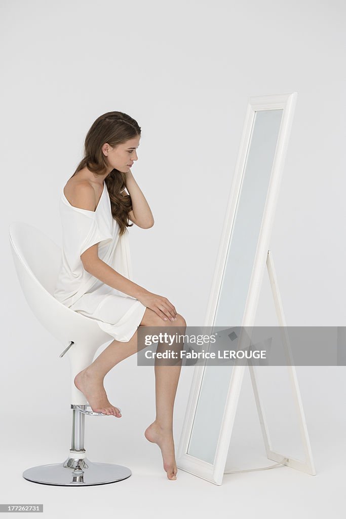 Woman sitting on a chair and looking at mirror