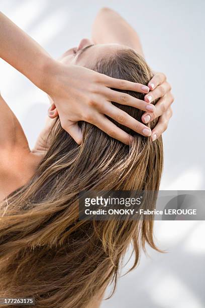 close-up of a woman holding her hair - long hair stock pictures, royalty-free photos & images