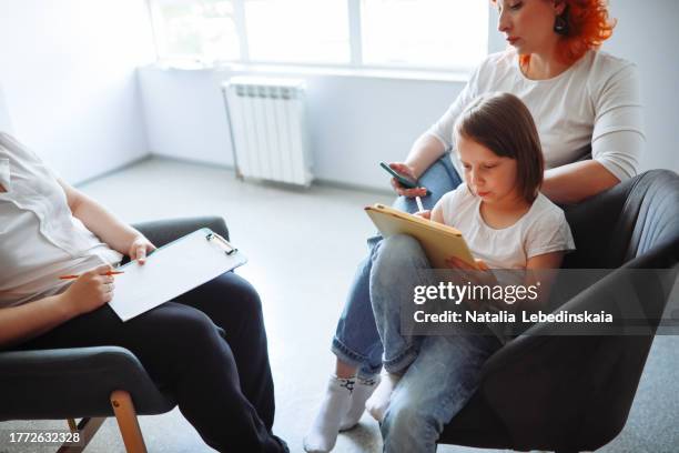 mother and child at therapist's office for gadget addiction and psychological assessments - office of clinical affairs stock pictures, royalty-free photos & images