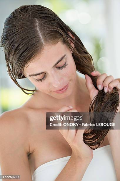 woman applying conditioner in her hair - conditioner imagens e fotografias de stock