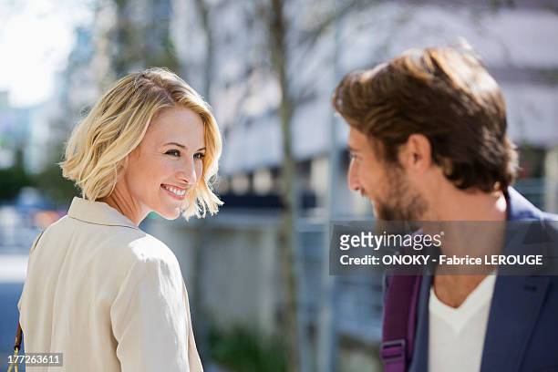 man and woman smiling at each other - flirten stockfoto's en -beelden
