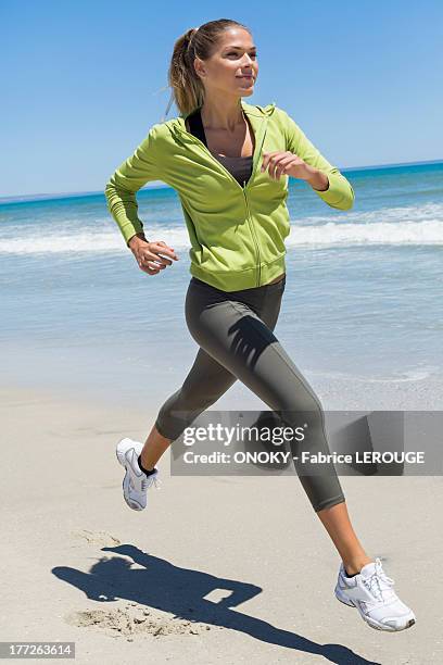 woman jogging on the beach - junge frau strand sand springen stock-fotos und bilder