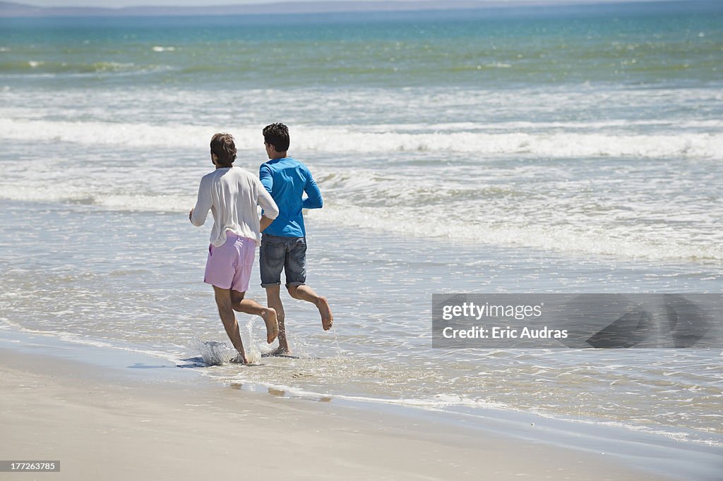 Two men running on the beach