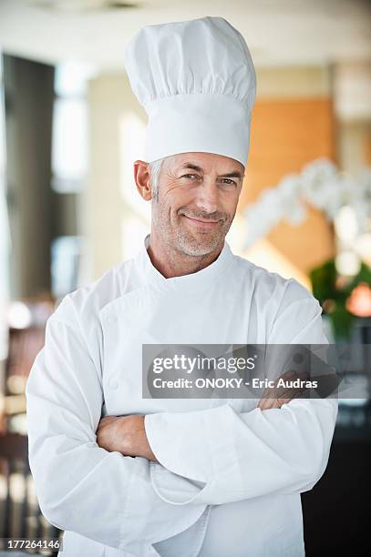 portrait of a chef smiling with arms crossed - toque de cuisinier photos et images de collection