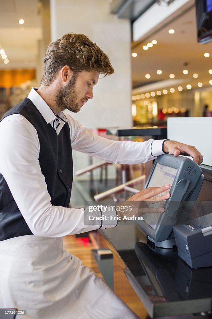 Waiter Using A Computer At Checkout Counter In A Restaurant High-Res ...