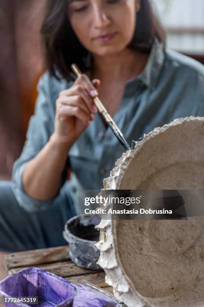 beautiful woman making papier mache vase on the porch of wooden house. - papier stock pictures, royalty-free photos & images