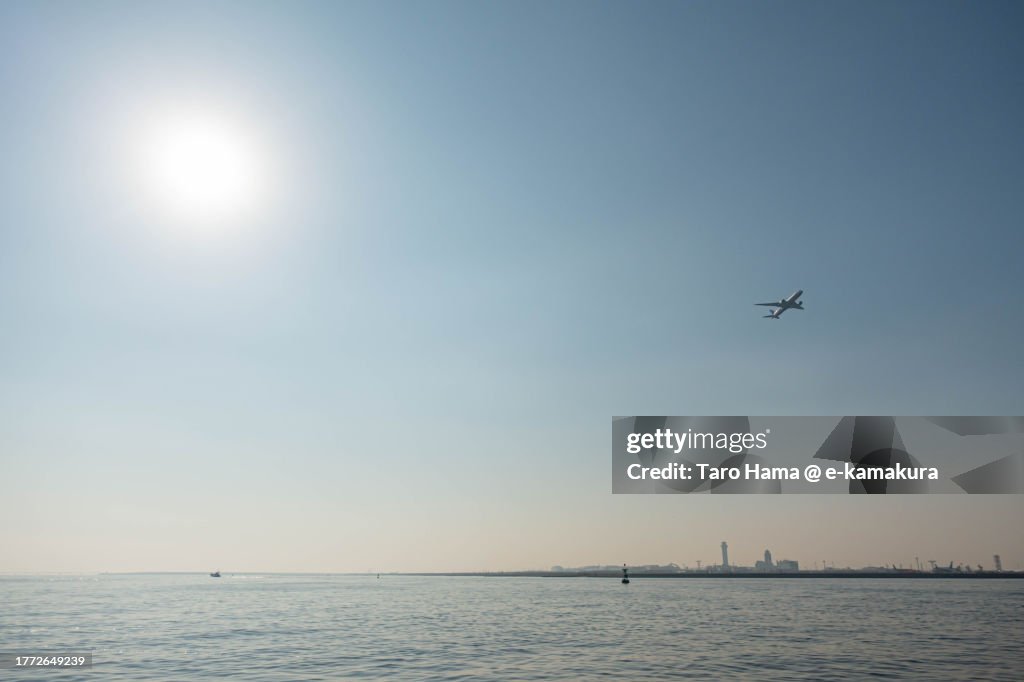 The airplane flying over the beach in Tokyo of Japan