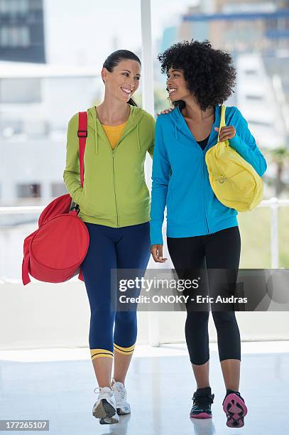 two happy female friends carrying gym bags - carrying sports bag foto e immagini stock