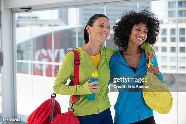 two happy female friends carrying gym bags - carrying sports bag foto e immagini stock