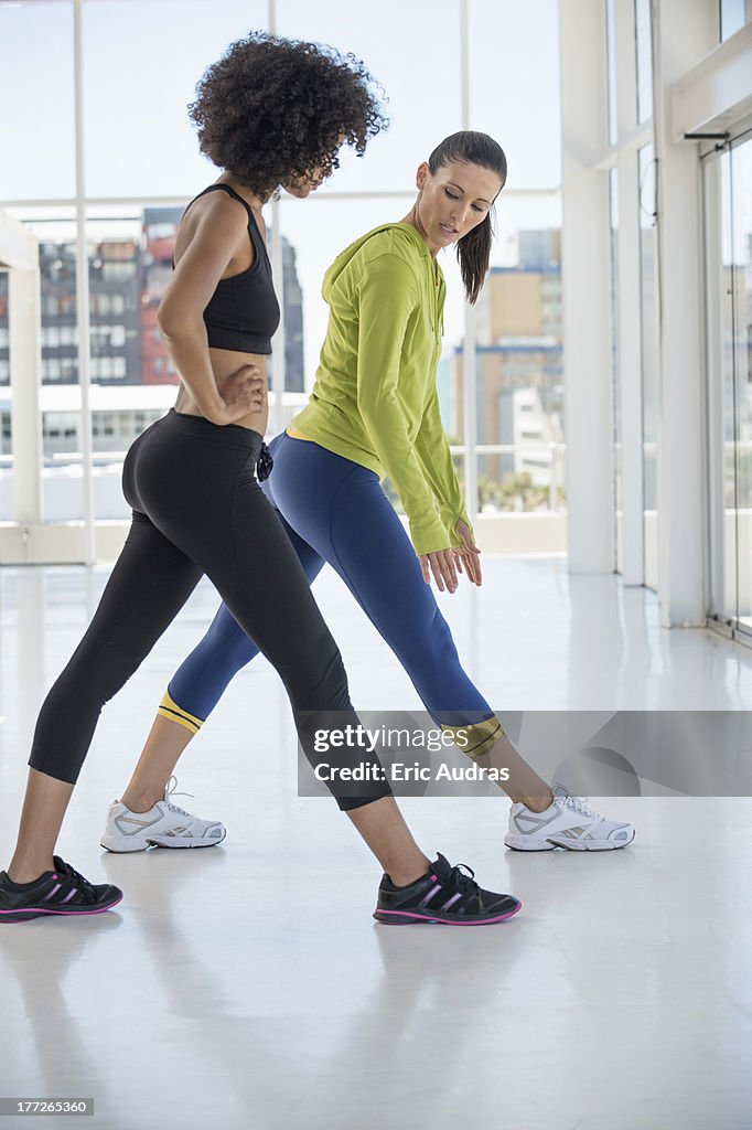 Woman exercising with her instructor in a gym