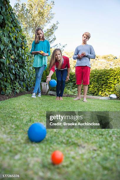 friends playing petanque in a garden - boules stock-fotos und bilder