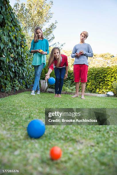 friends playing petanque in a garden - petanque stock pictures, royalty-free photos & images