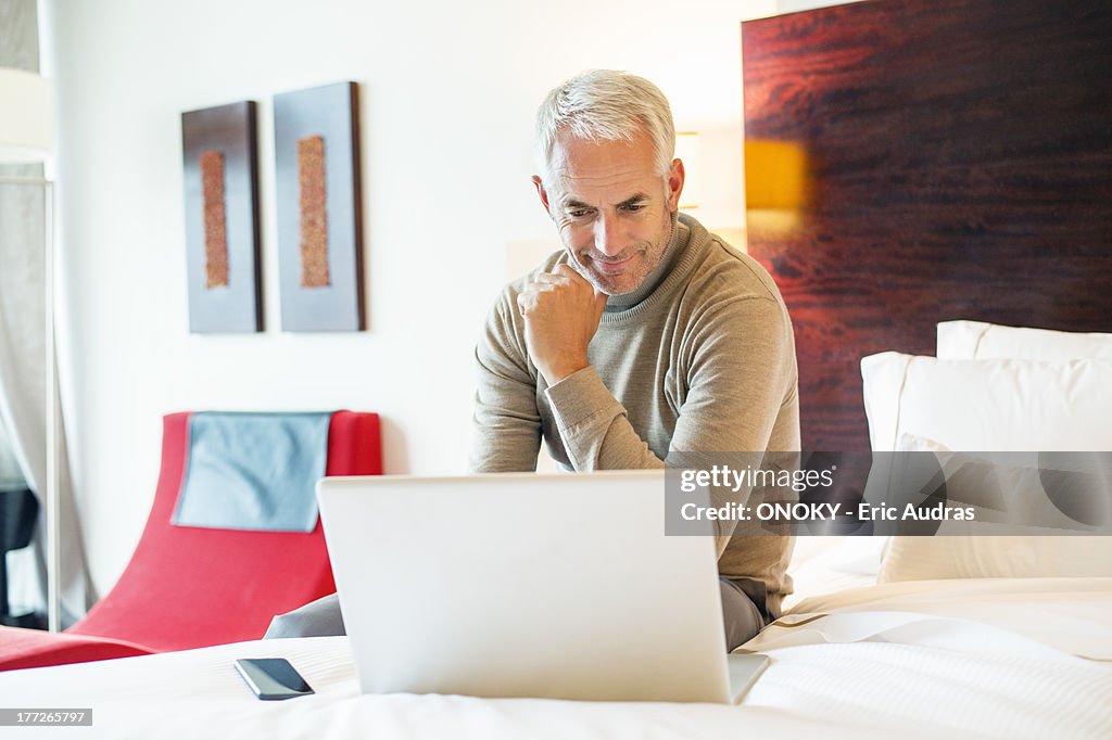 Man using a laptop in a hotel room