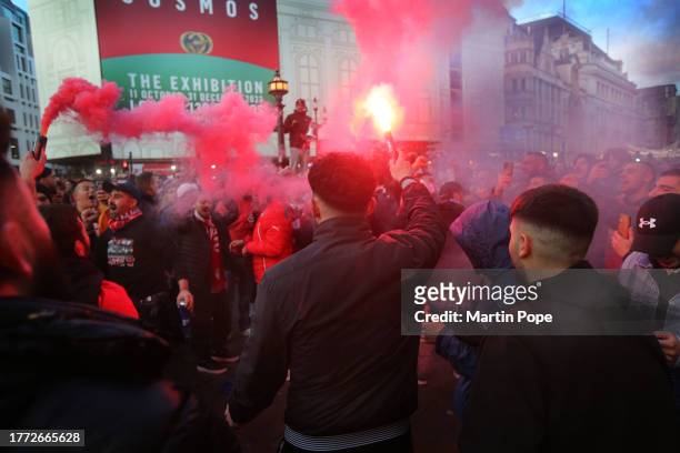 Fans chant and sing in a smoke laden atmosphere during a pre-match celebration at Piccadilly Circus on November 9, 2023 in London, England....