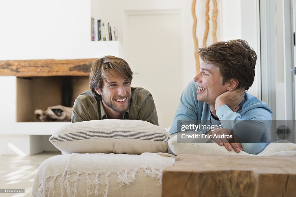 Two male friends smiling on the bed