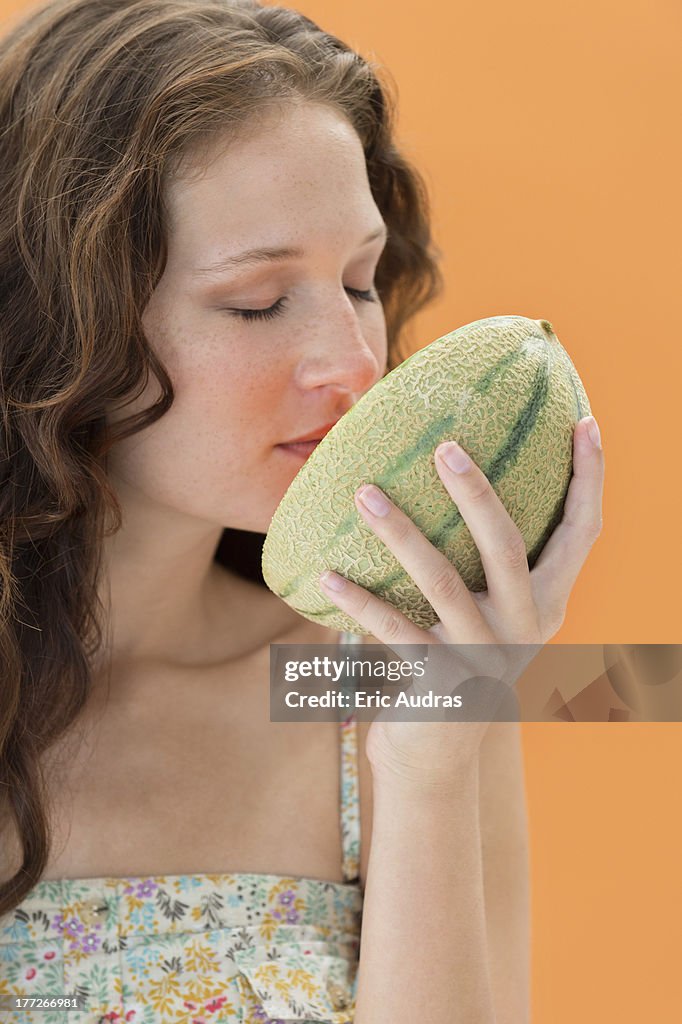 Close-up of a woman smelling melon