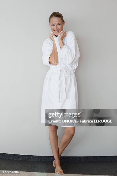 portrait of a smiling woman in bathrobe at spa - bademantel stock-fotos und bilder