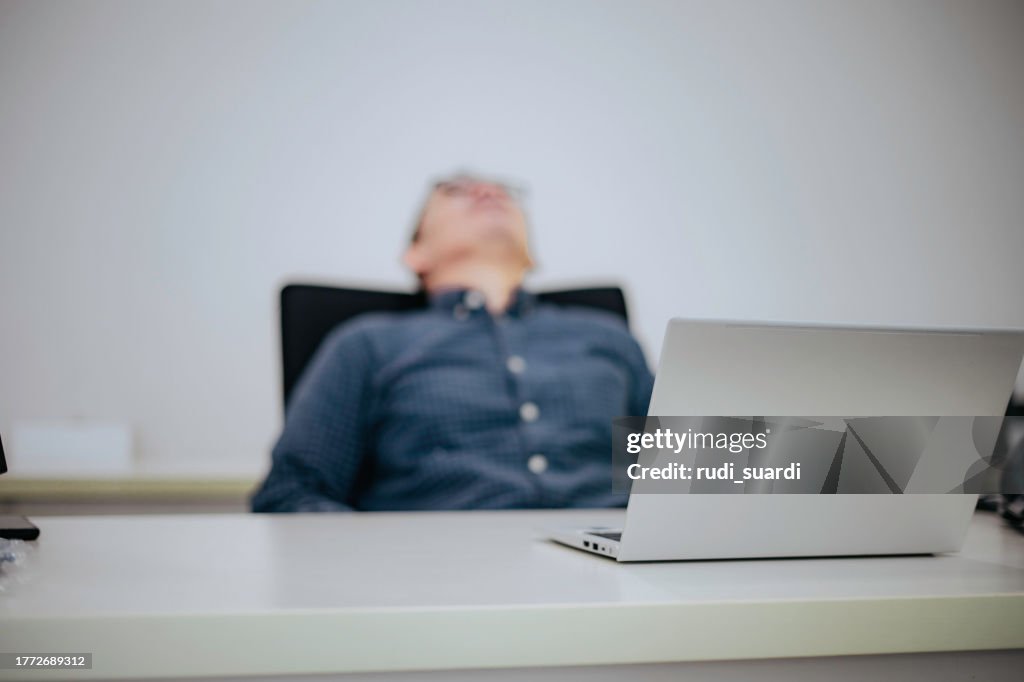 Shot of a business man looking stressed while working in a modern office