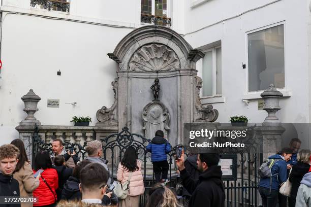 Daily life in Brussels with crowds at one of the tourist attractions in the city, the Manneken Pis or the Little man Pee or peeing boy or le Petit...