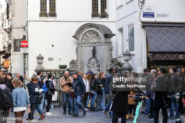 Daily life in Brussels with crowds at one of the tourist attractions in the city, the Manneken Pis or the Little man Pee or peeing boy or le Petit...