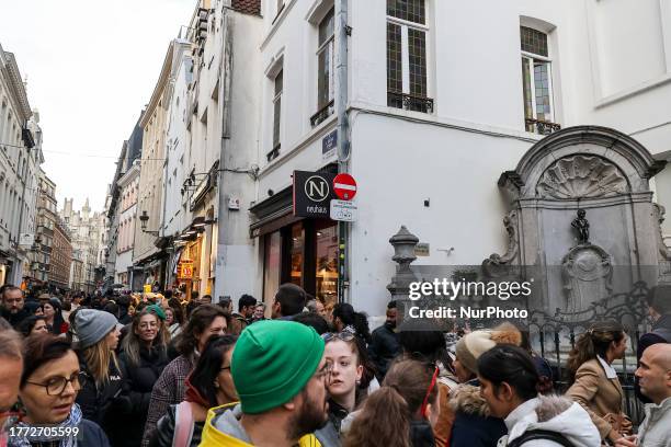 Daily life in Brussels with crowds at one of the tourist attractions in the city, the Manneken Pis or the Little man Pee or peeing boy or le Petit...