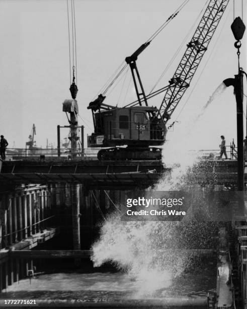 An air lift cleaning chalk from the pans of sheet pile, ahead of underwater concreting, during construction of the Thames Barrier on the River Thames...