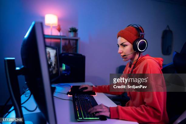 dedicated young caucasian female gamer playing video games on computer - heroes icon stock pictures, royalty-free photos & images