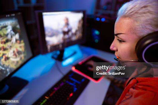 close-up of female gamer, playing video games on her pc during a live stream - heroes icon stock pictures, royalty-free photos & images