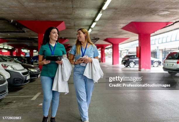 strolling nurses discuss matters in garage - matters stock pictures, royalty-free photos & images