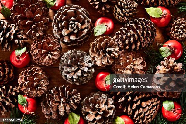 top view of pine cones making christmas composition on rustic wooden table - legno di pino foto e immagini stock