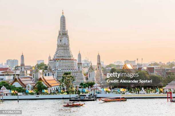 wat arun buddhist temple and chao phraya river on a sunny day, bangkok, thailand - bangkok stock-fotos und bilder
