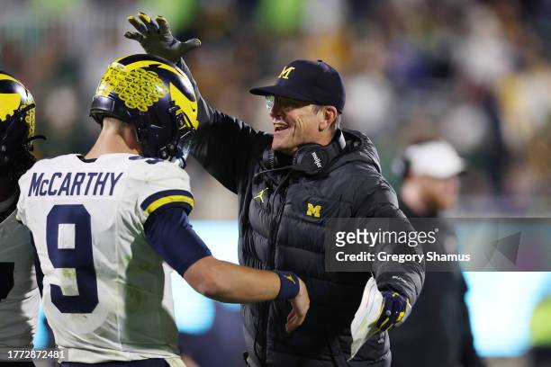 Head coach Jim Harbaugh of the Michigan Wolverines congratulates J.J. McCarthy after one of his second half touchdown passes while playing the...