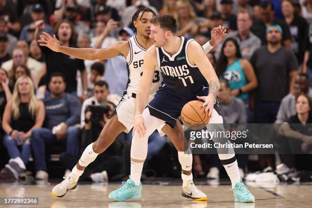 Luka Doncic of the Dallas Mavericks handles the ball against Tre Jones of the San Antonio Spurs during the NBA game at Frost Bank Center on October...