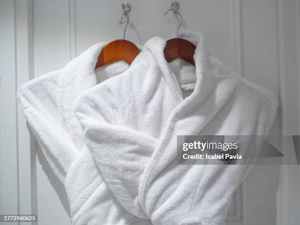 luxury bathrobes hanging on back of bathroom door - door hanger stock pictures, royalty-free photos & images
