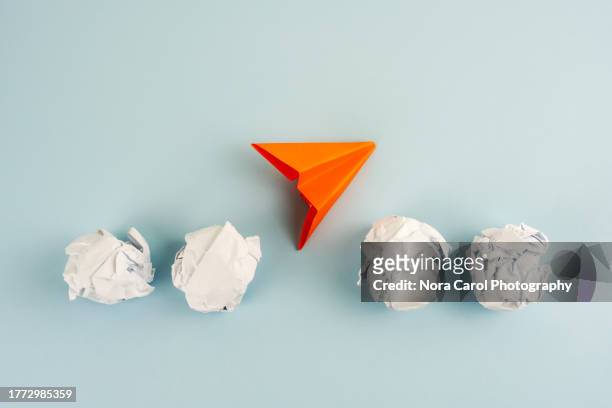 crumpled paper ball and paper plane - paper plane stock-fotos und bilder
