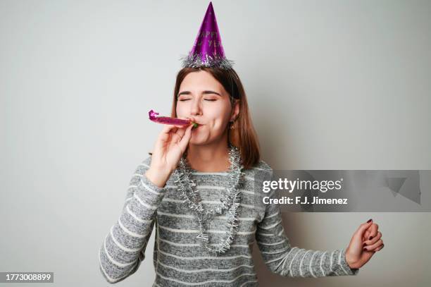 woman celebrating new year's eve in photo booth - party favor foto e immagini stock