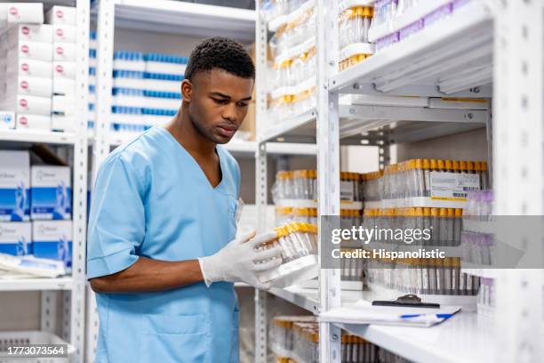 nurse taking inventory of medical supplies at a laboratory - medische artikelen stockfoto's en -beelden