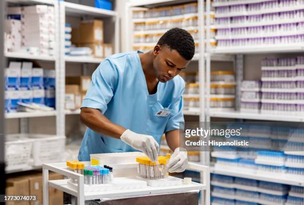 nurse working at the laboratory organizing test tubes - medical lab stock pictures, royalty-free photos & images