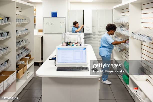 nurses searching for medicines in the pharmacy at the hospital - kabinet dokter stockfoto's en -beelden