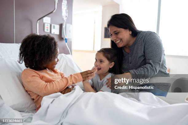 happy girl talking to a friend visiting her at the hospital - er visit stock pictures, royalty-free photos & images