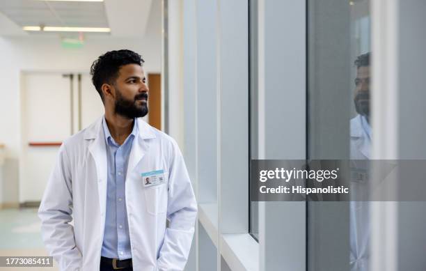 tired doctor working at a hospital and looking through the window - civil imagens e fotografias de stock
