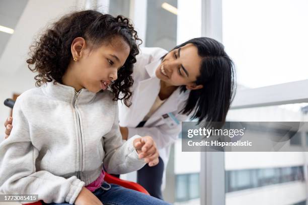 girl with cerebral palsy talking to a doctor at the hospital - hydrocephalus stock pictures, royalty-free photos & images