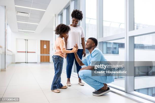 happy girl giving a high-five to a nurse at the hospital - black man high 5 stockfoto's en -beelden
