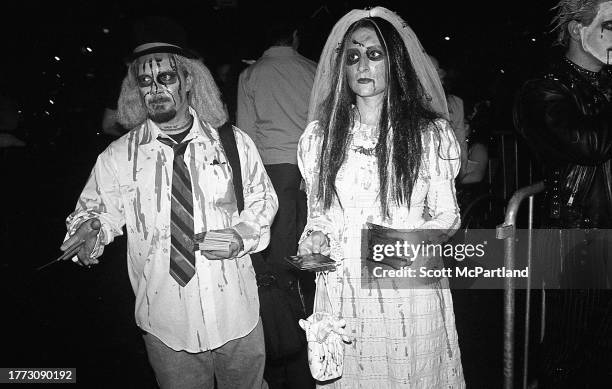 View of a zombie groom and bride as they hand out pamphlets during the 30th annual Village Halloween Parade, on 6th Avenue, New York, New York,...