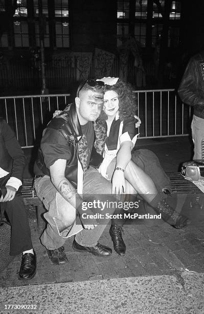 Portrait of two costumed people as they embrace on a park bench during the 30th annual Village Halloween Parade, on 6th Avenue, New York, New York,...