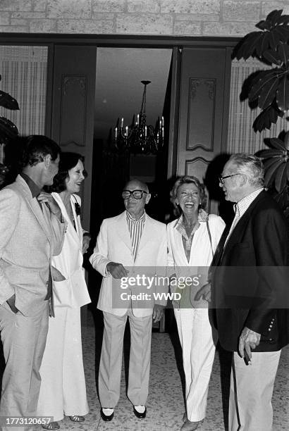 Louis Jourdan , Audrey Wilder, Irving "Swifty" Lazar, Berthe Jourdan, and Billy Wilder attend a party at the Lazar residence in Los Angeles,...