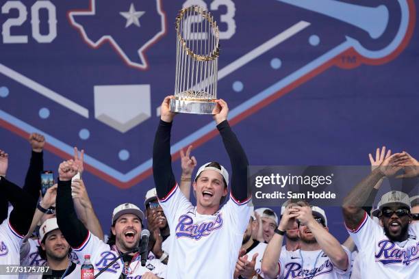 Corey Seager of the Texas Rangers lifts the Commissioner's Trophy during the World Series Championship celebration at Globe Life Field on November...